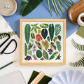 Framed artwork with leaf patterns on a table with craft supplies
